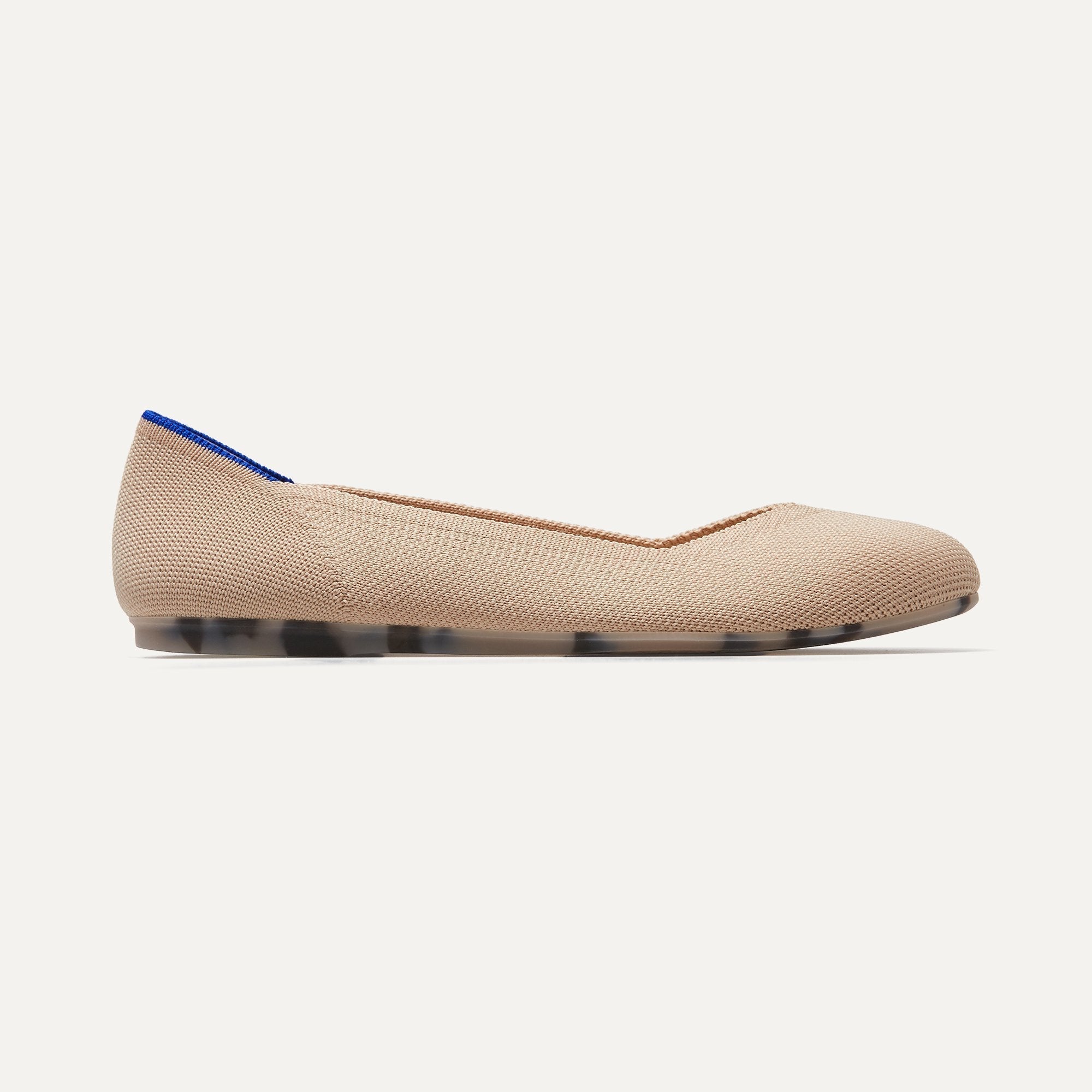 The Flat round toe shoe in Ecru shown from a side view showing the outsole.