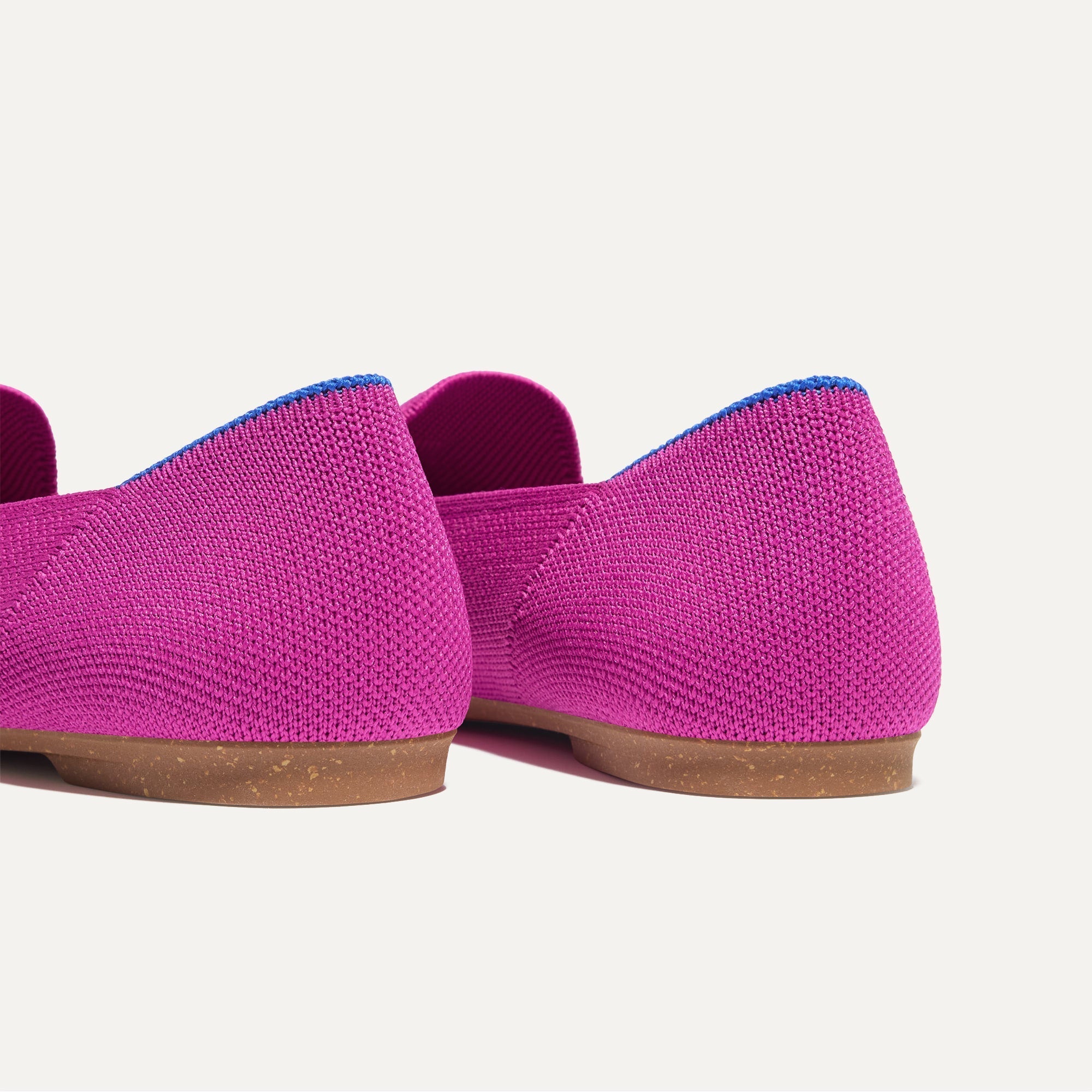 Close up of the heel of The Almond Tassel Loafer in Pink Bramble, with Rothy's signature blue halo. 