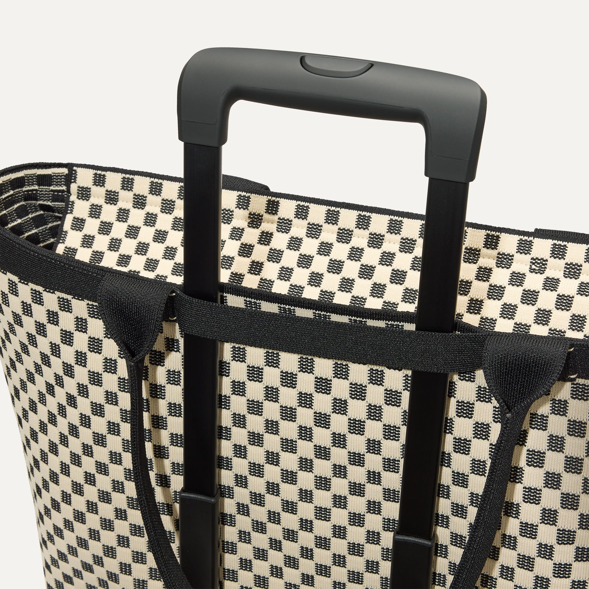 The Zip Travel Tote shown attached to a rolling suitcase using the wrap-around band.