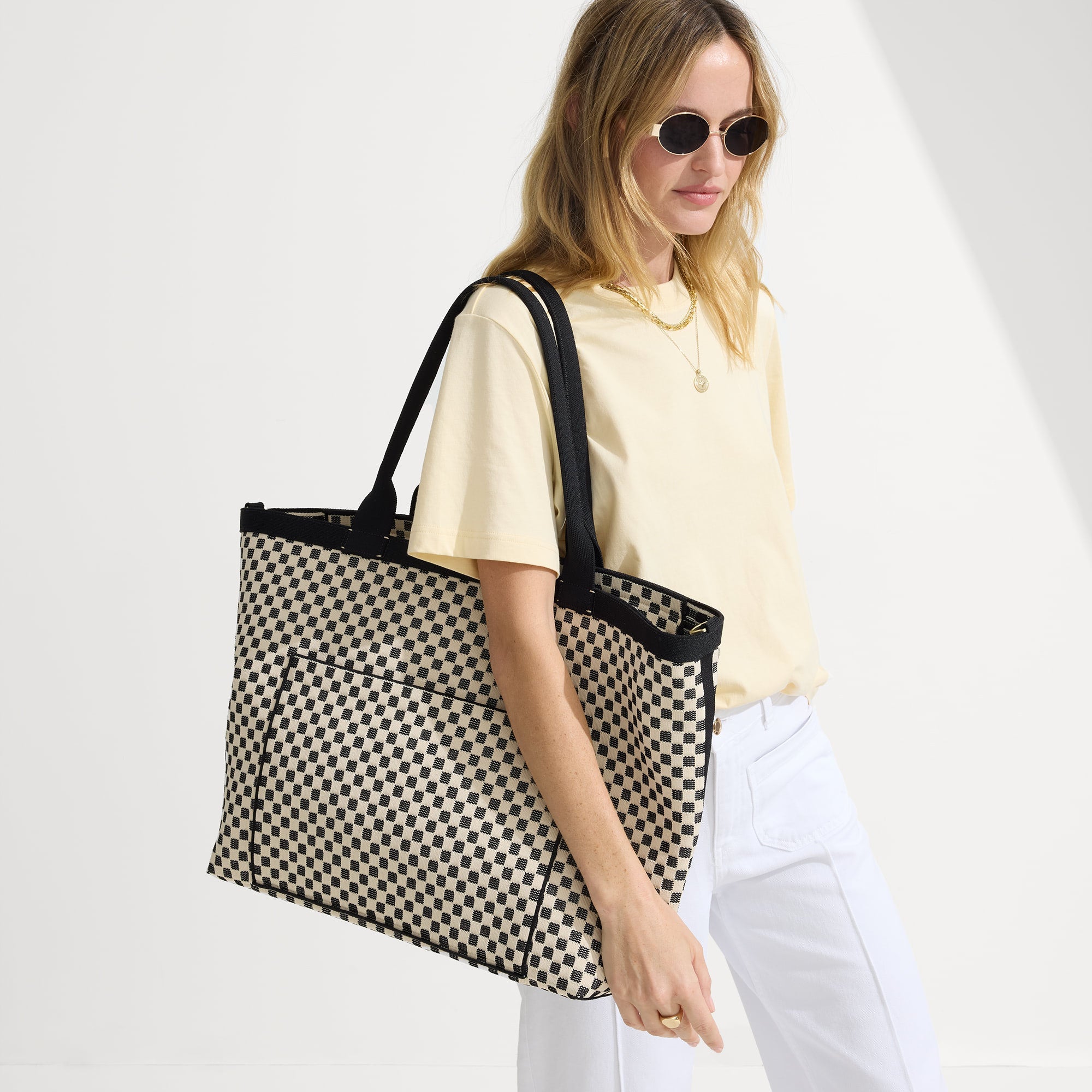 Model holding The Zip Travel Tote in Tuxedo Midi Check.